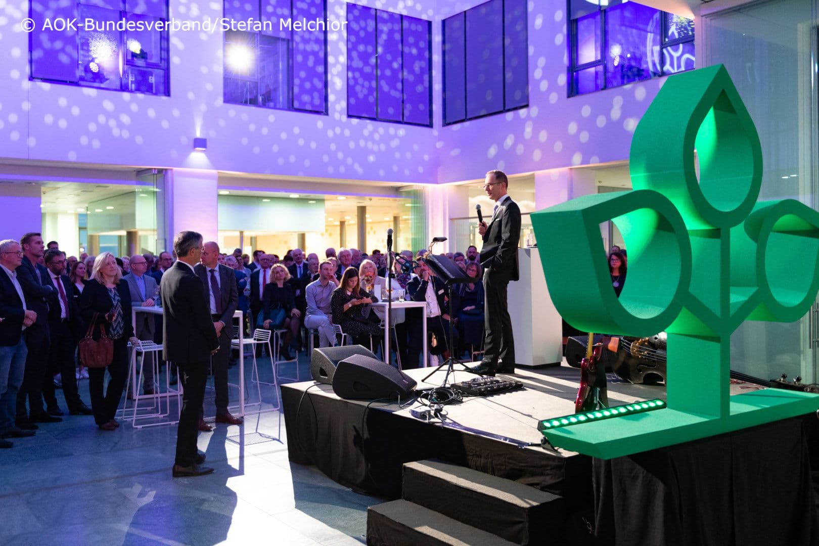 In lockerer Position: Staatssekretär Thomas Steffen (BMG) bei seiner Rede im Atrium des AOK-Bundesverbandes