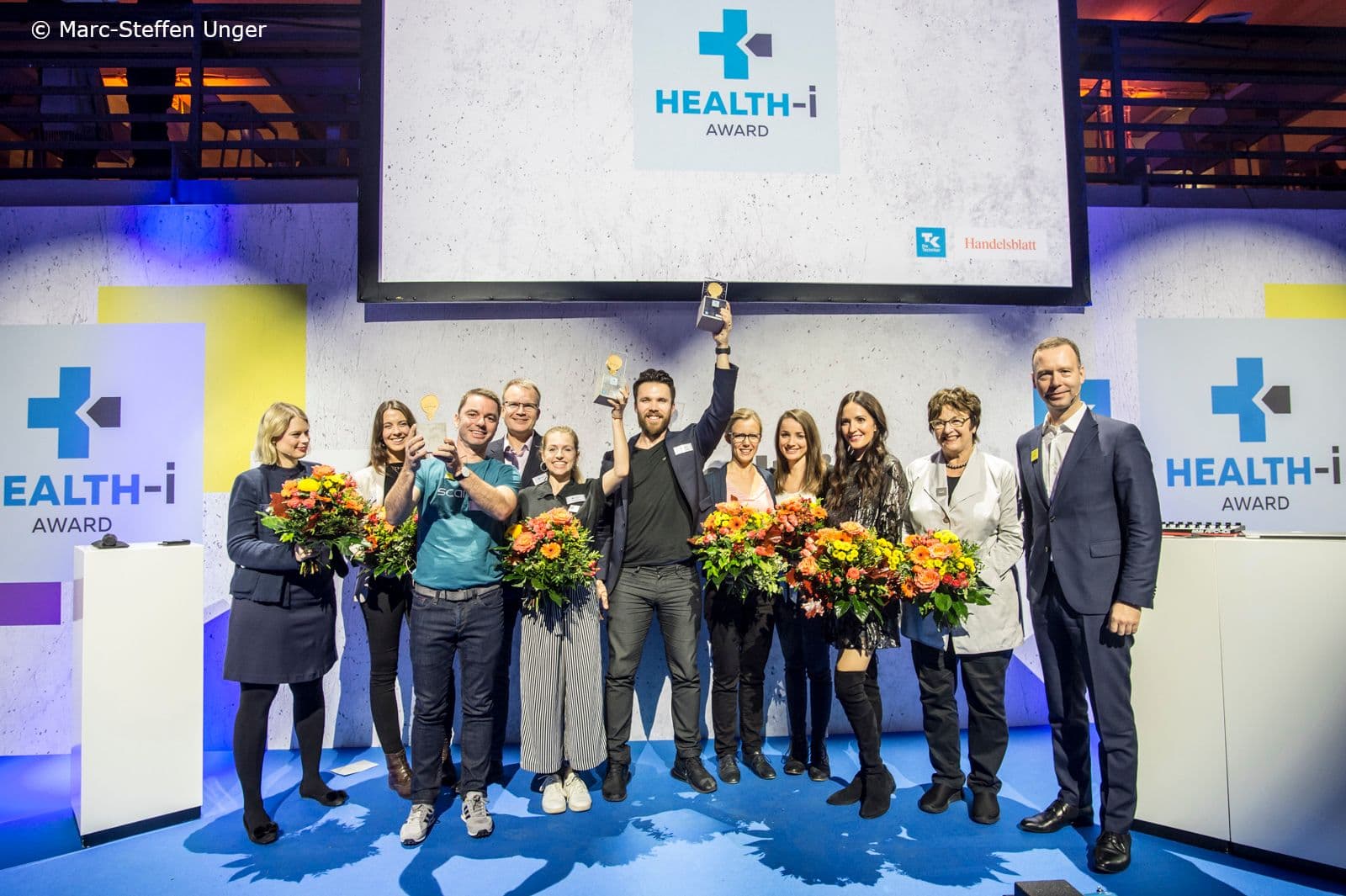 Gruppenfoto mit den Gewinnern, der Jury sowie Moderatorin