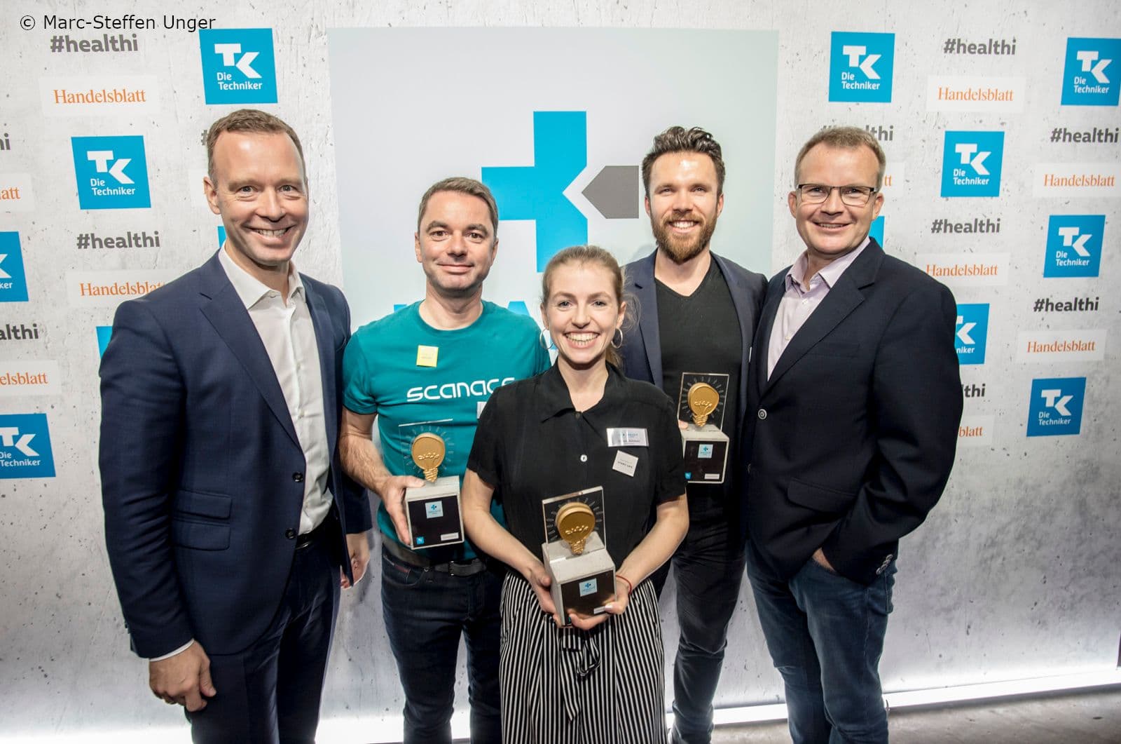 Sven Afhueppe (Handelslblatt ) (l.) und  Jens Baas (TK) (r.) mit den Gewinnern Frank Boehme (Scanacs), Christina Roitzheim (Contenance) und Maximilian Greschke (Recare) (2.v.l.nr.)