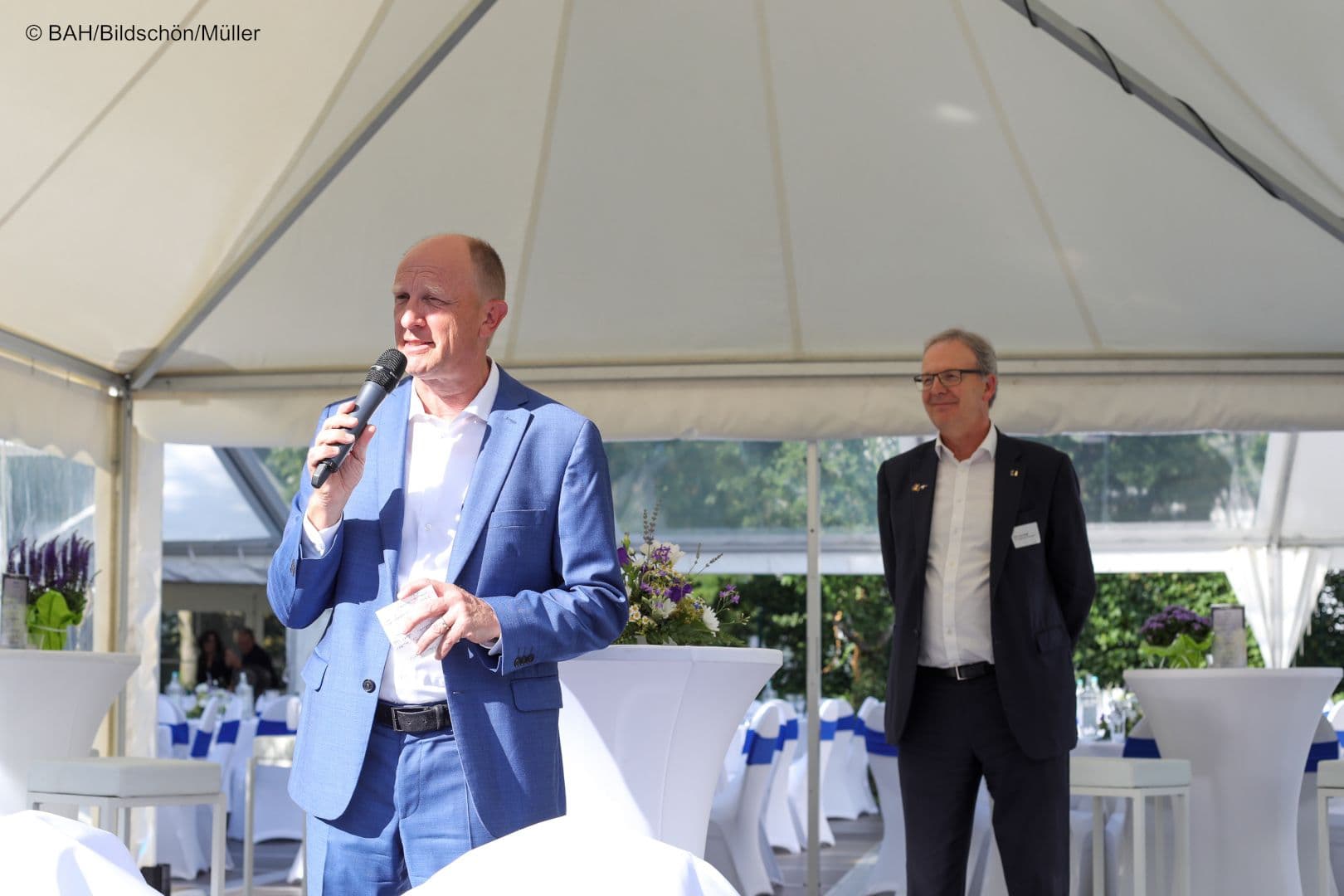 BAH-Vorstandsvorsitzender Jörg Wieczorek begrüßt die Gäste, Axel Voss (Mitglied des EU-Parlaments, CDU) wartet auf seinen Auftritt.