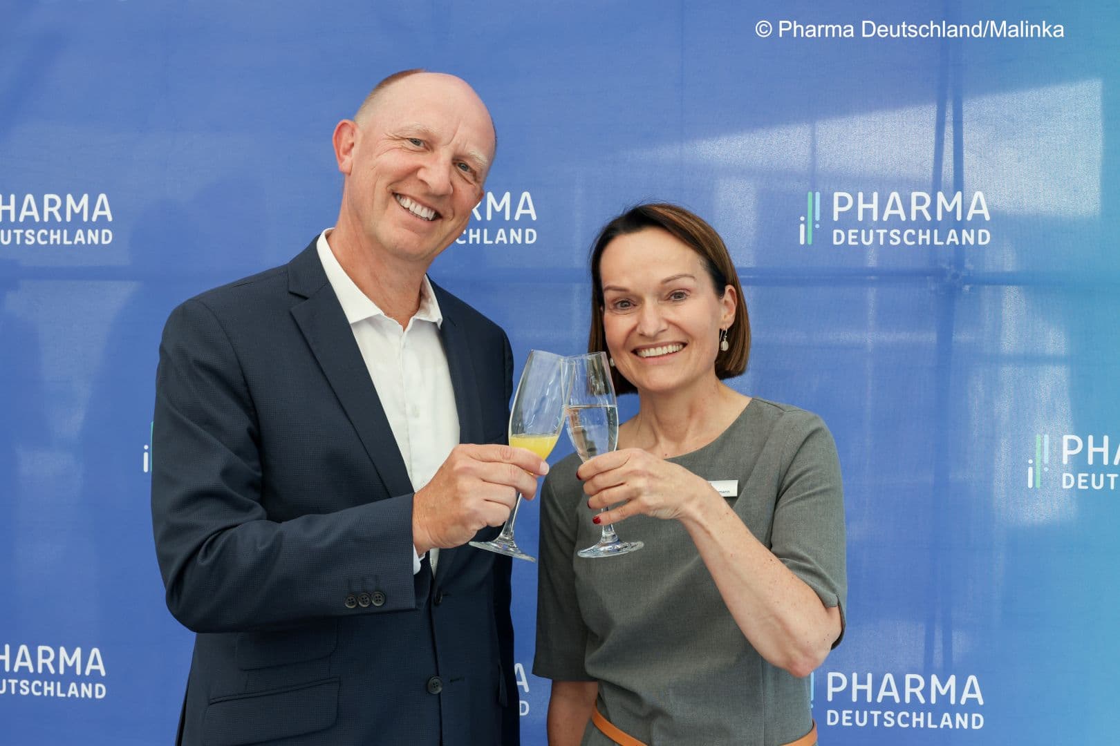 Vorstandsvorsitzender Jörg Wieczorek und Hauptgeschäftsführerin Dorothee Brakmann stoßen auf Pharma Deutschland an.