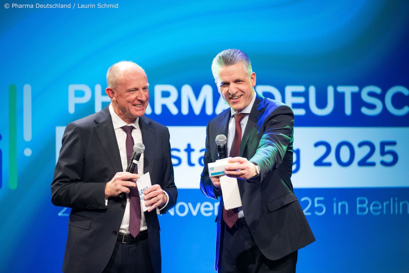 Jörg Wieczorek, Vorstandsvorsitzender von Pharma Deutschland, (l.) lässt den Chef des Bundeskanzleramtes Thorsten Frei den Preis eines Generikums schätzen.