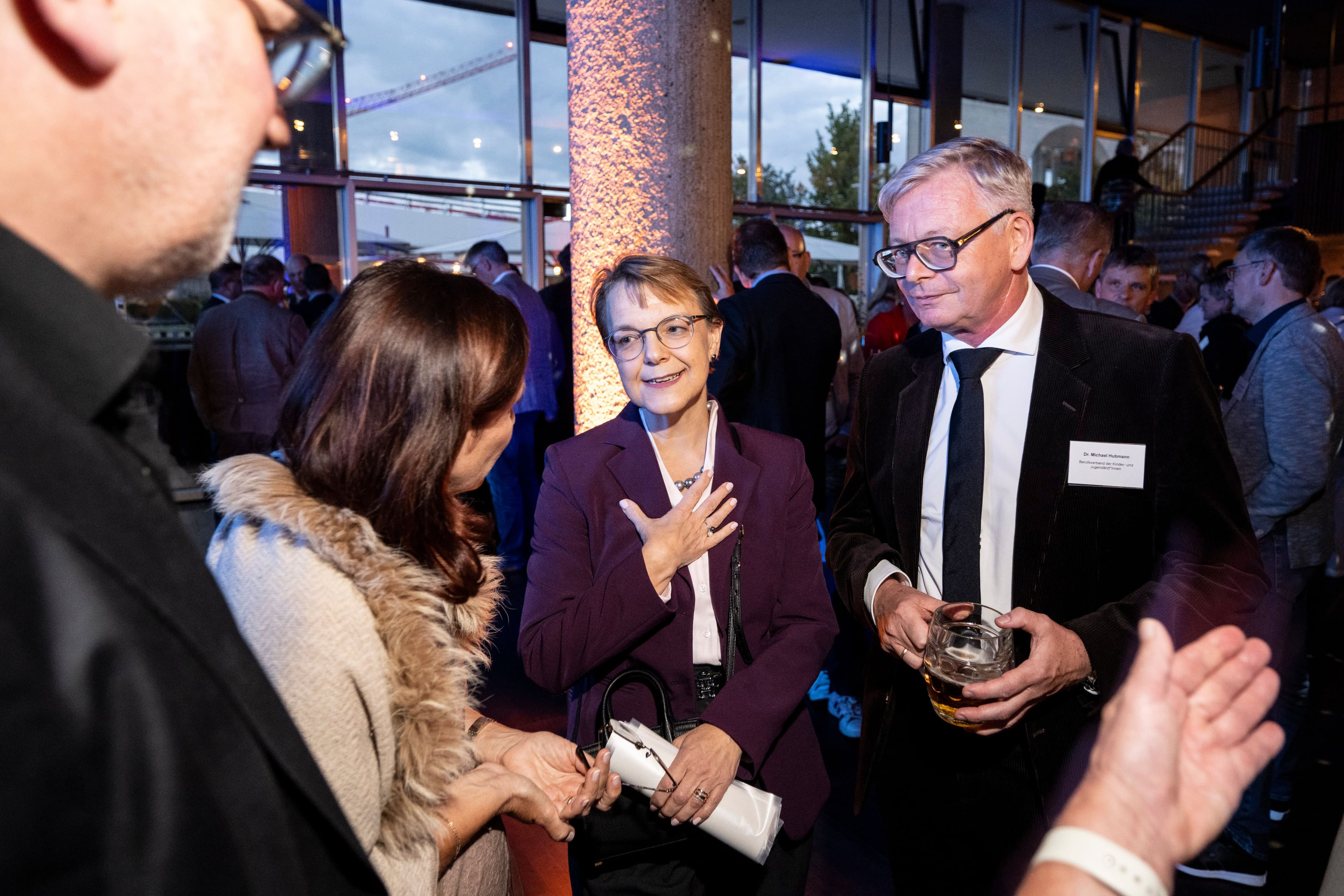 BMG-Staatssekretärin Katja Kohfeld (M.) redet mit Nicola Buhlinger-Göpfarth (Hausärztinnen- und Hausärzteverband (l.) und Michael Hubmann (bvkj) (r.)